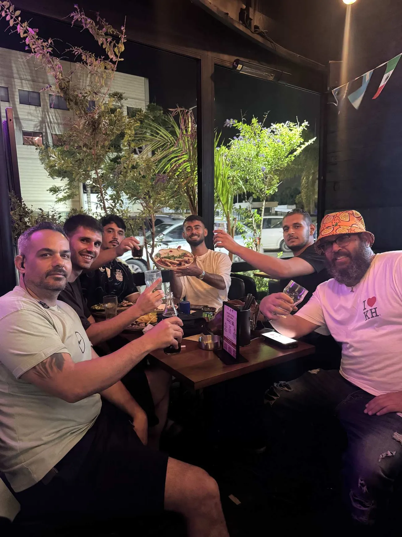 חבורה מרימה כוסית סביב שולחן